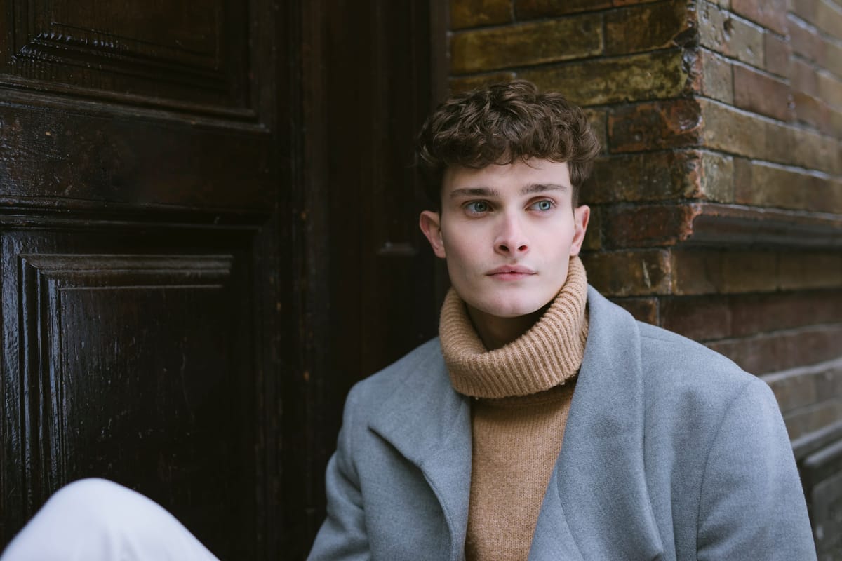 Portrait book d'un jeune homme en manteau gris et col roulé camel à Paris